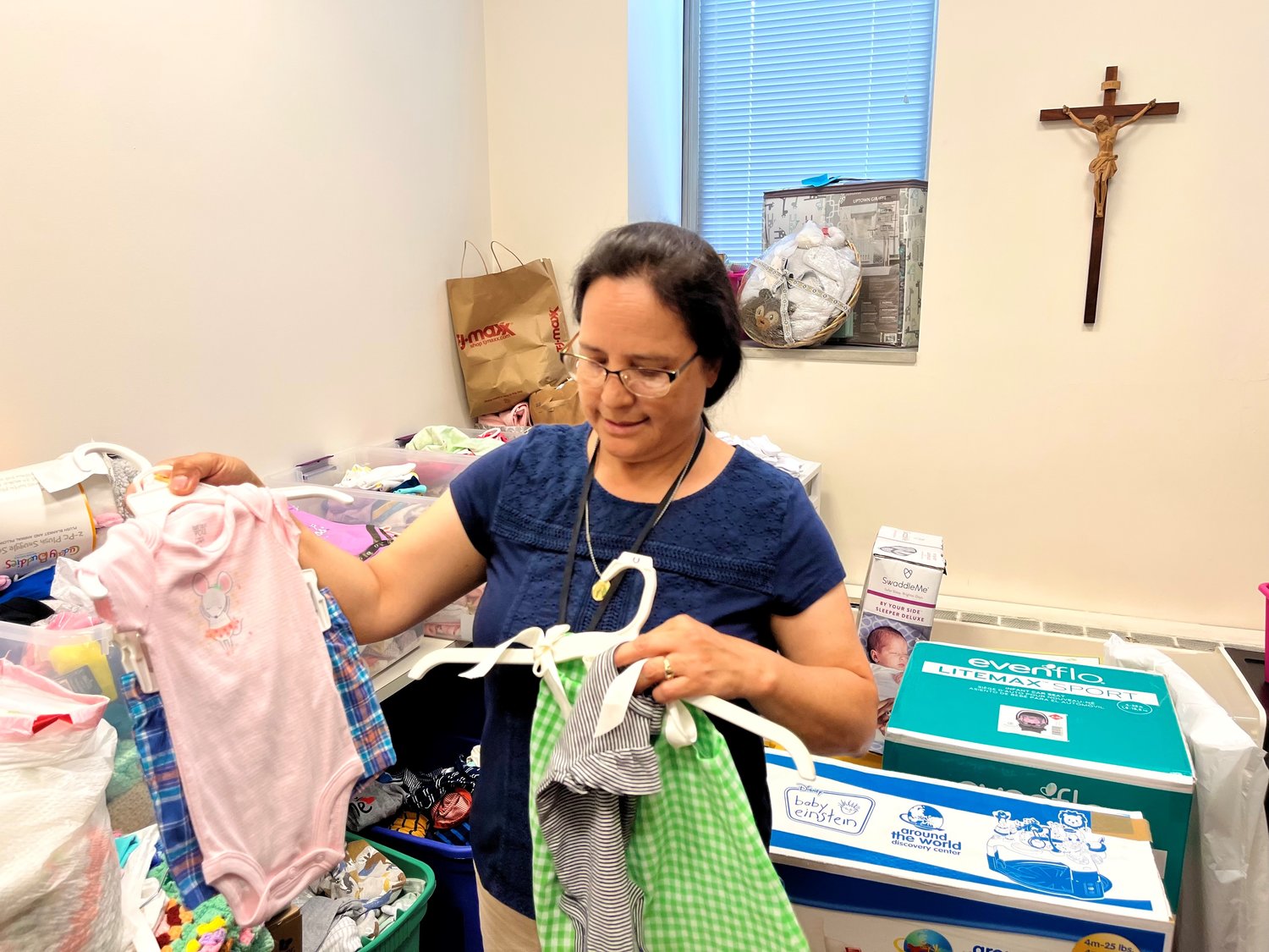Marissa Kelly revisa donaciones de ropita de bebe. Ella sirve en el proyecto Gabriel, un ministerio diocesano de los servicios sociales católicos de Rhode Island Island